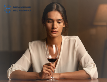 Девушка смотрит на бокал вина